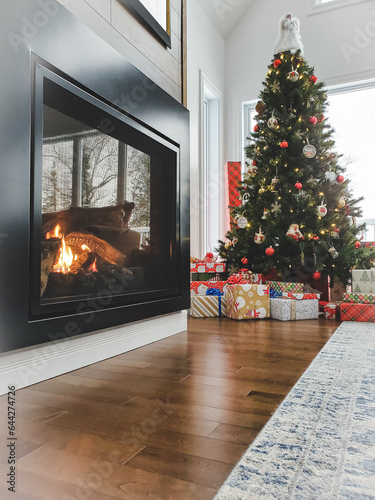christmas tree and gifts in a trendy decor with a gas fireplace burning