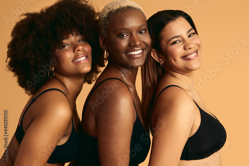 Smiling multiethnic women in underwear standing close to each other