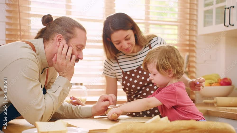 Caucasian attractive couple baking bakery with son in kitchen at home. Caucasian attractive couple baking bakery with son in kitchen at home.