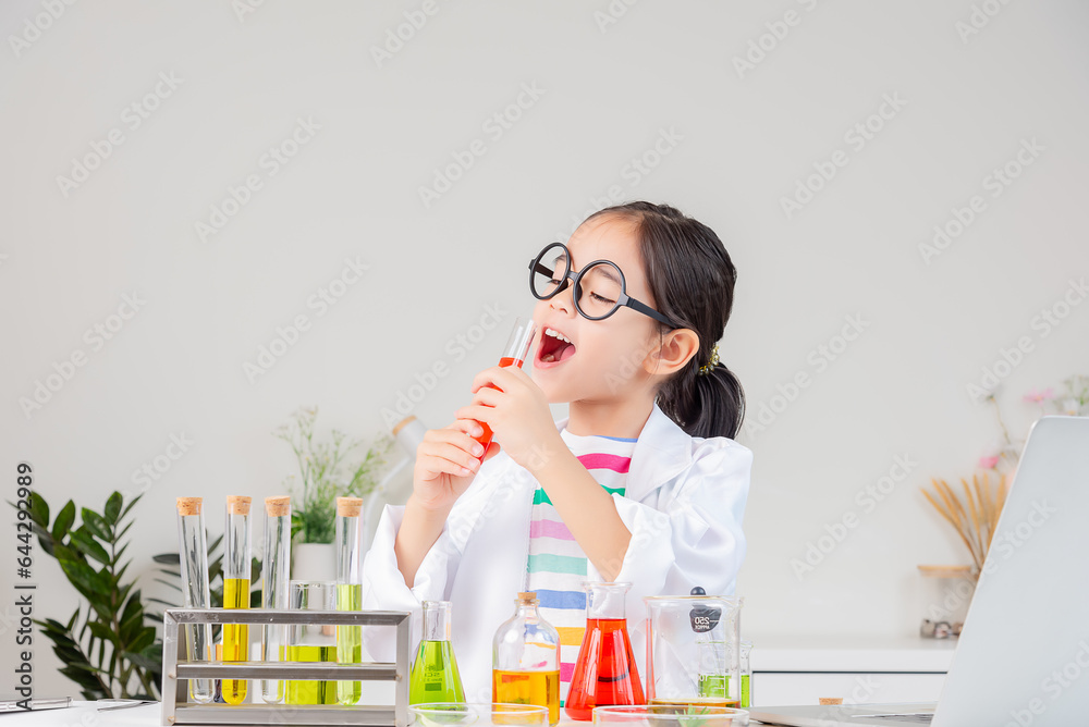 Asian little girl working with test tube science experiment in white classroom Asian little girl working with test tube science experiment in white classroom