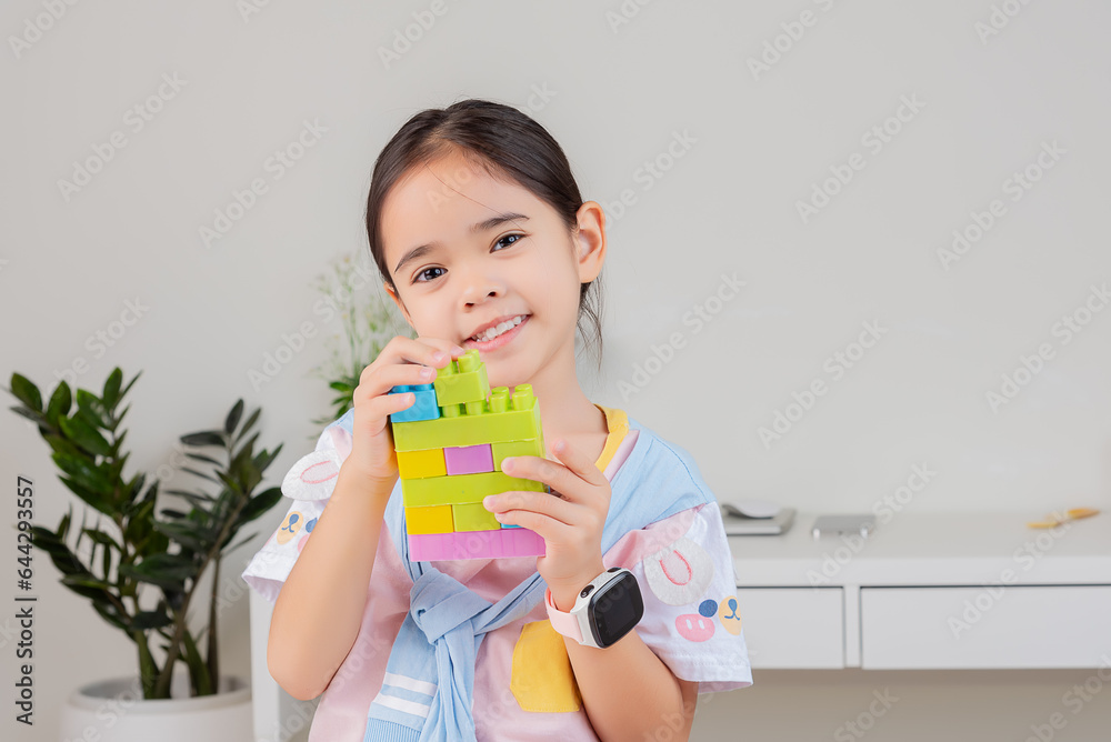 little girl is happy Playing colorful block puzzles. in the white room little girl is happy Playing colorful block puzzles. in the white room