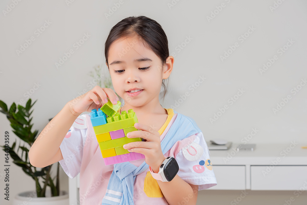 little girl is happy Playing colorful block puzzles. in the white room little girl is happy Playing colorful block puzzles. in the white room