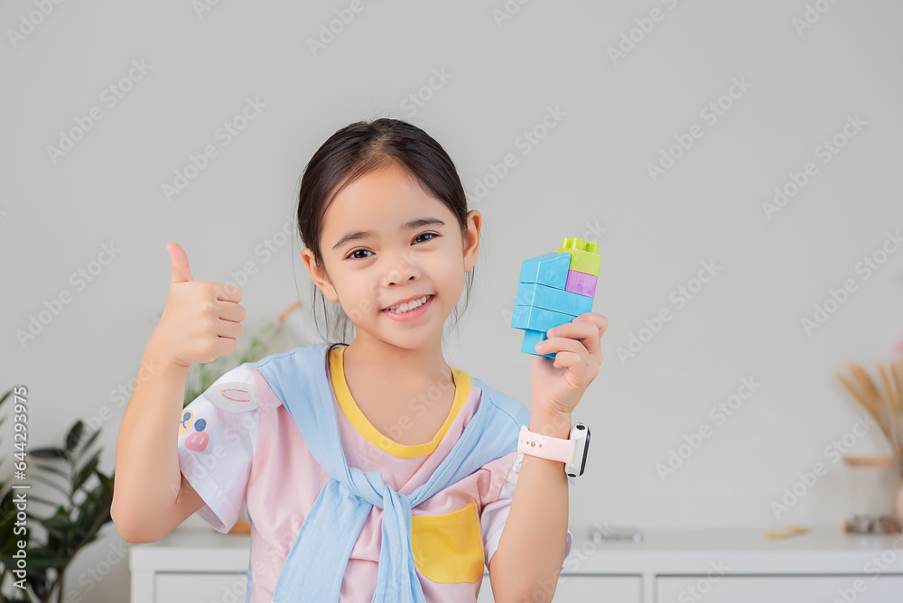 little girl is happy Playing colorful block puzzles. in the white room little girl is happy Playing colorful block puzzles. in the white room