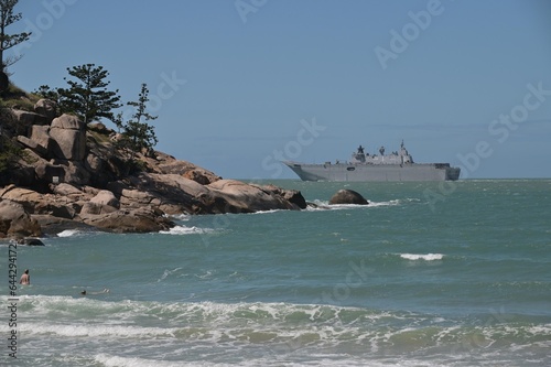 Tourists looking at HMAS Adelaide Australian landing helicopter dock ship passing by Magnetic Island Queensland Australia