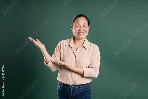 Gangang middle-aged Asian female portrait posing on blue background © 1112000
