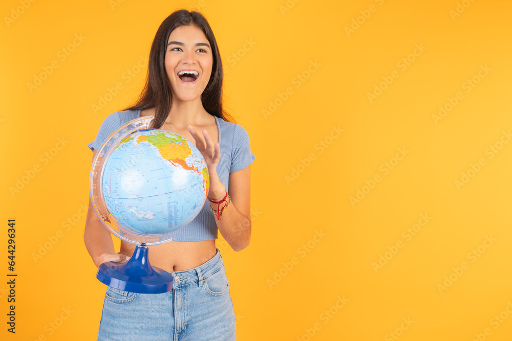 Happy young hispanic woman holding a world ball