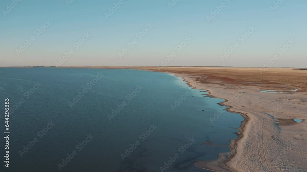 This stock video shows a beautiful clear blue lake with a sandy coast. This video will decorate your projects related to nature, travel, reservoirs, lakes, sandy shores.