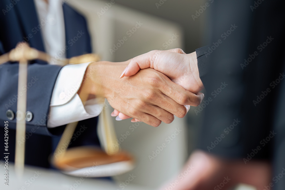 Businessman shaking hands to seal a deal with his partner lawyers or attorneys discussing a contract agreement - obrazy, fototapety, plakaty 