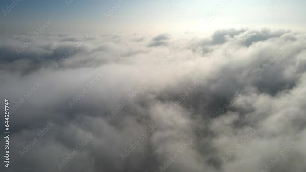 Aerial shot of flying over a layer of soft clouds at dawn Aerial shot of flying over a layer of soft clouds at dawn
