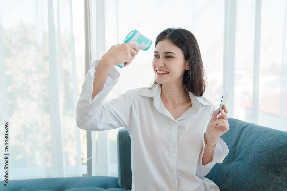 Portrait of relaxed asian young woman taking medicine and measuring temperature with thermometer, Infected patient at home medical self treatment, self recover health care concept. Portrait of relaxed asian young woman taking medicine and measuring temperature with thermometer, Infected patient at home medical self treatment, self recover health care concept.