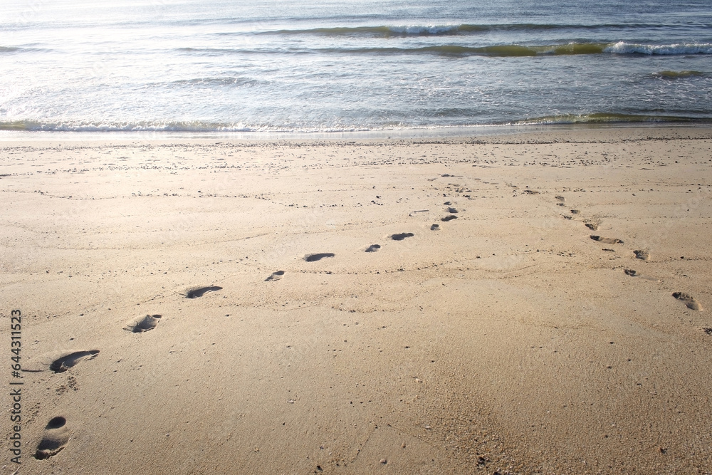 footprints in the sand walking on a beach with a change of direction footprints in the sand walking on a beach with a change of direction