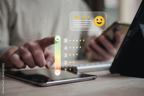 customer service evaluation and feedback rating. costumer review concept, man using phone chooses happy smiling face photo