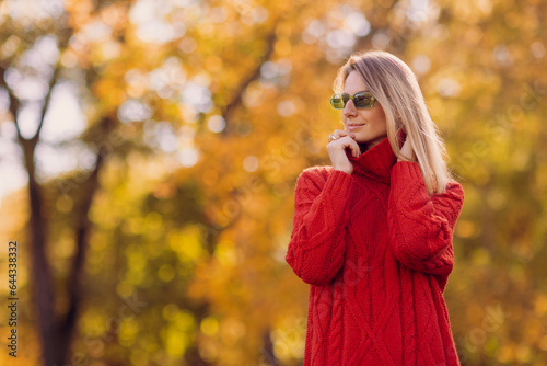 a girl in a red sweater walks in the autumn in the park, the concept of the autumn season