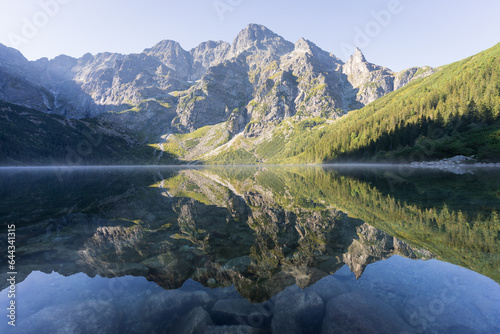 Majestic rocky mountain reflecting in pristine crystal clear alpine lake, Poland, Europe