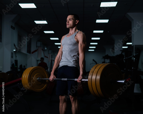 Caucasian man doing bicep exercises with dumbbells in the gym. 