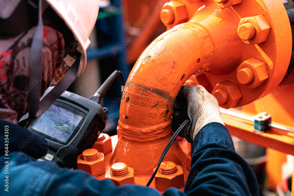 Non-destructive testing technicians are checking the thickness of elbow ...