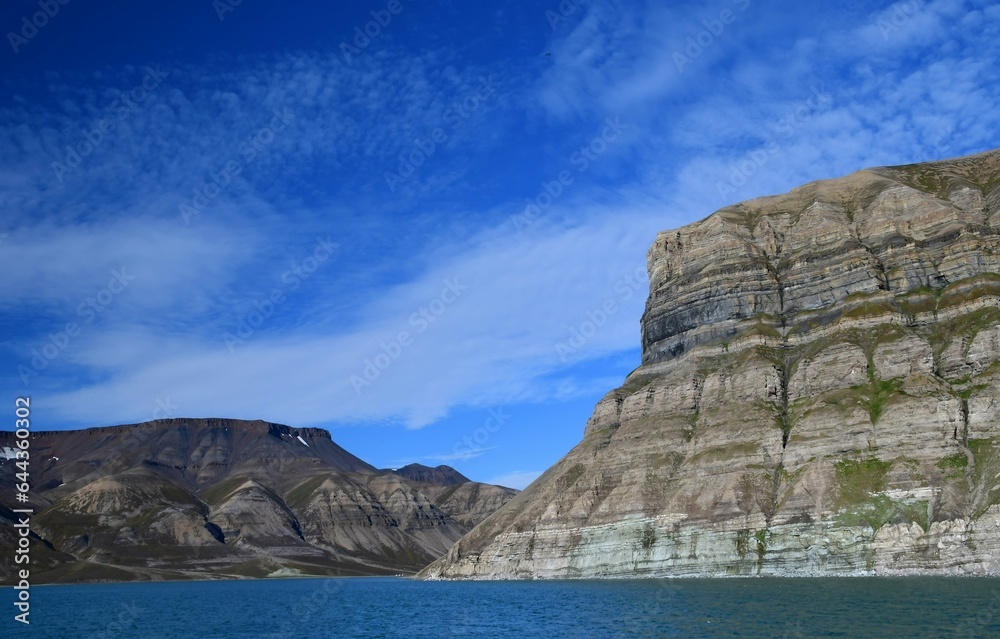 the heavily striated skansen cliffs in the billefjorden on a boat tour on a sunny day  near longyearbyen, svalbard, norway 