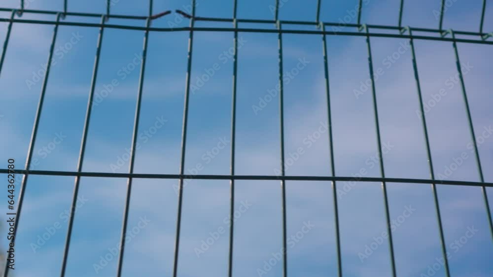 Blue sky with clouds through metal mesh fence. Blue sky with clouds through metal mesh fence.