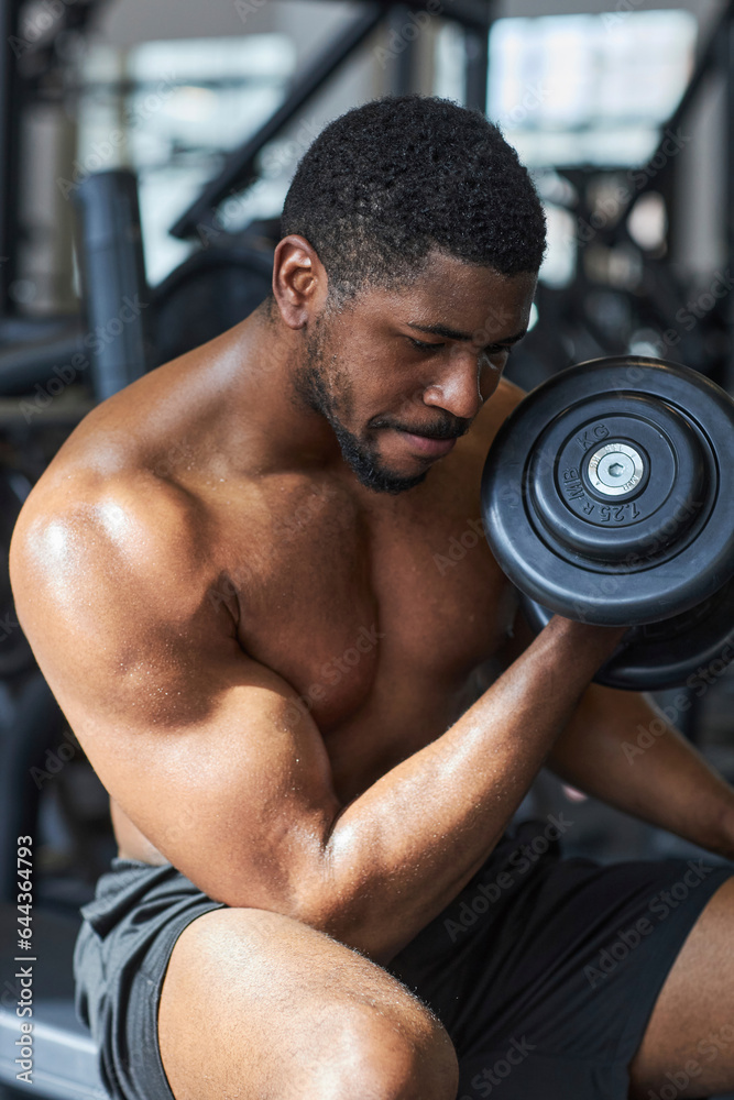 Young man exercising with dumbbell in gym Young man exercising with dumbbell in gym
