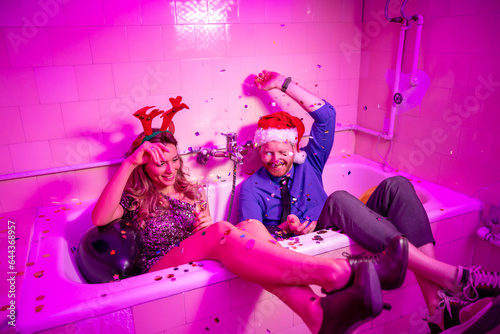 Canvas Print Couple throwing confetti and drinking champagne at New Year's party midnight cou