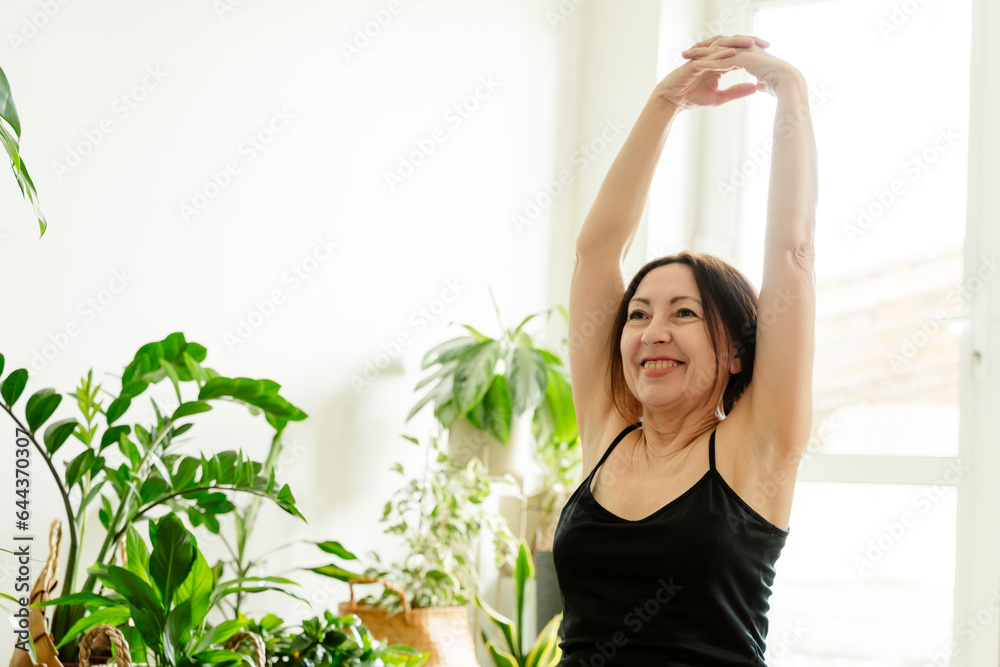 Smiling woman stretching hands and exercising at home Smiling woman stretching hands and exercising at home