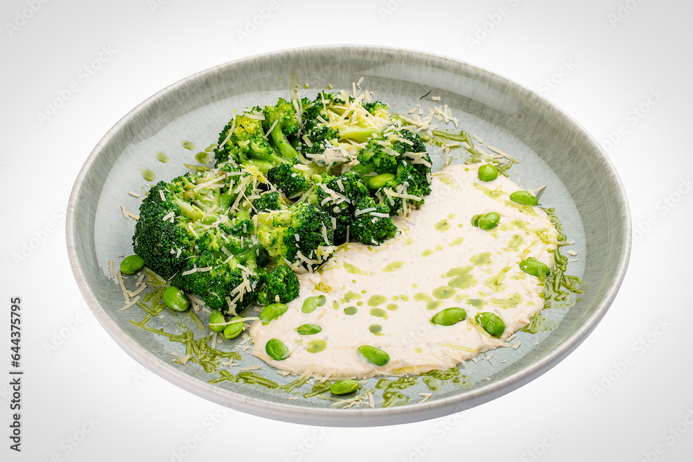 Steamed brocolli with cream sauce and parmesan. Isolated on a white background.