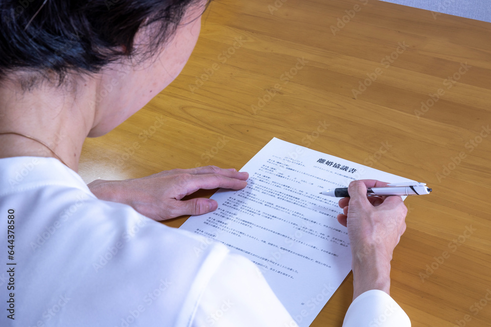 Naklejka premium 離婚協議書にサインする女性