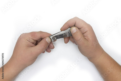 Male hand manicure with nail clipper isolated on white background