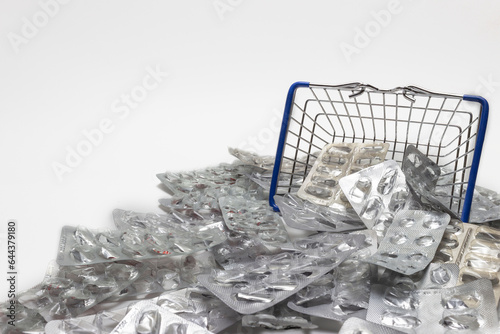 decorative shopping basket with empty pill boxes against the background of empty pill boxes