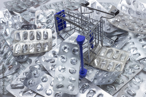 Empty decorative shopping basket stands on a pile of empty packages of medicines, drug unavailability concept