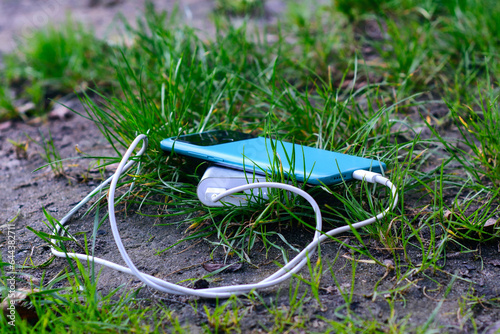 Portable charger charges a smartphone in nature. Power Bank on a journey to charge gadgets.