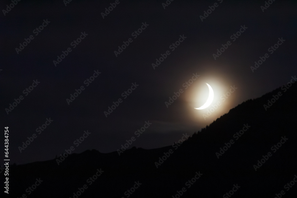 Croissant de lune décroissante, crescent moon over mountain at dusk