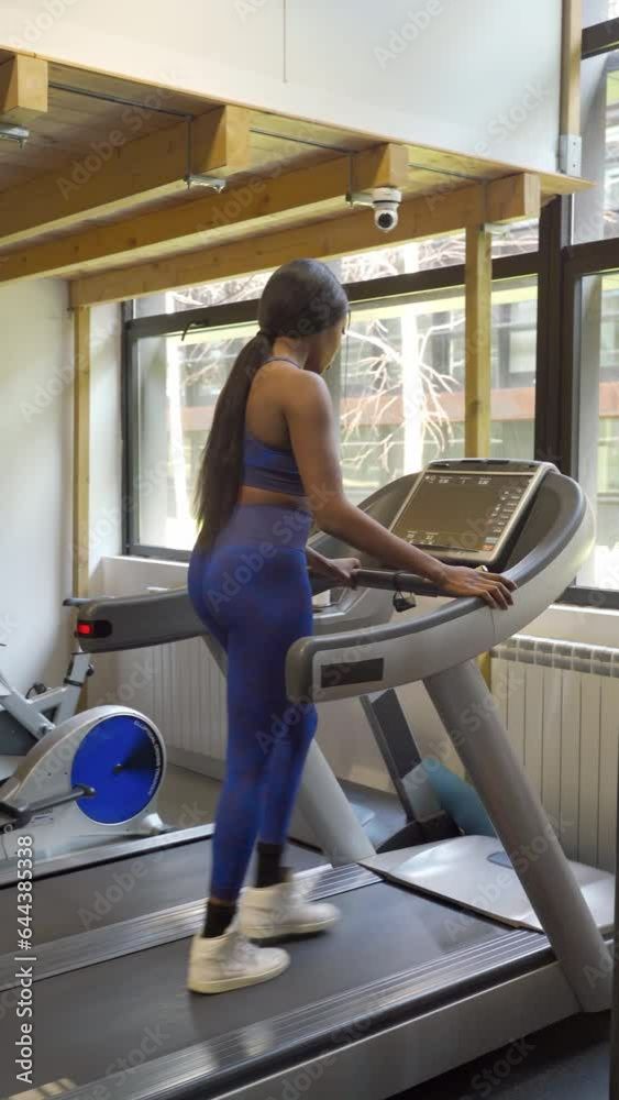 Black woman doing running exercises inside a gymnasium