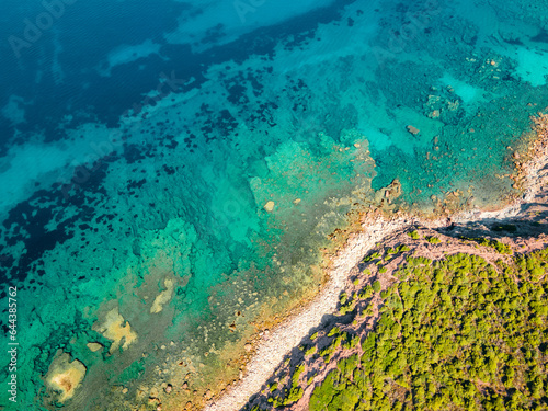 Top view of the turquoise sea near the rocky shore. Italy Sardinia