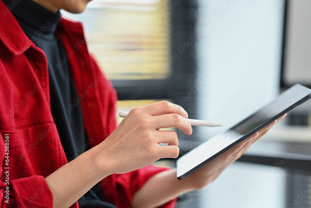 Closeup view of modern business man holding paper cup and using digital tablet at office desk Closeup view of modern business man holding paper cup and using digital tablet at office desk