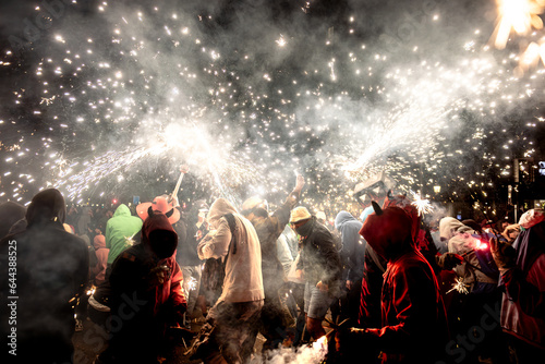 Unrecognizable people on passeig de Gracia street enjoying Correfoc festival at night in Barcelona photo