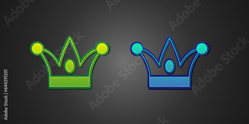 Green and blue Jester hat with bells isolated on black background. Clown icon. Amusement park funnyman sign. Vector photo