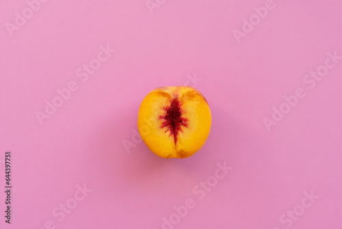 Peach on a pink background. Sliced peach on a pink background. Women's health theme.