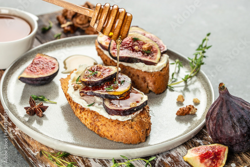 Bruschettas with raw fig, cream cheese, walnuts and honey. Concept healthy and balanced eating. place for text, top view