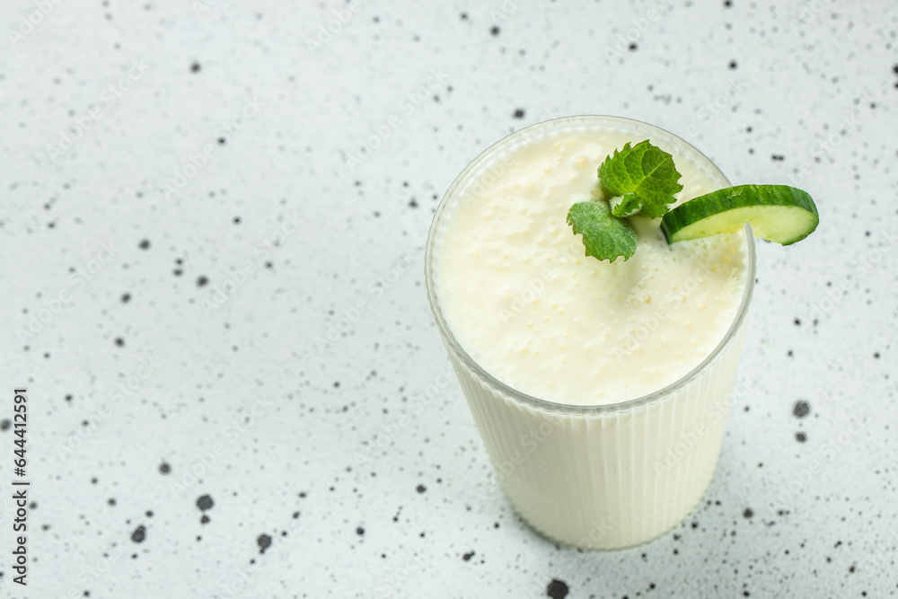 Ayran drink with mint and cucumber on a light background, organic healthy products. Detox and clean diet concept Ayran drink with mint and cucumber on a light background, organic healthy products. Detox and clean diet concept
