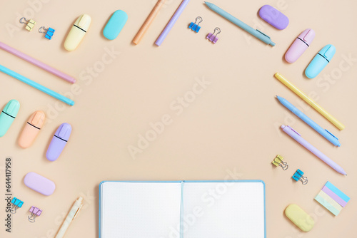 Frame of pastel color school and office stationery on yellow background.