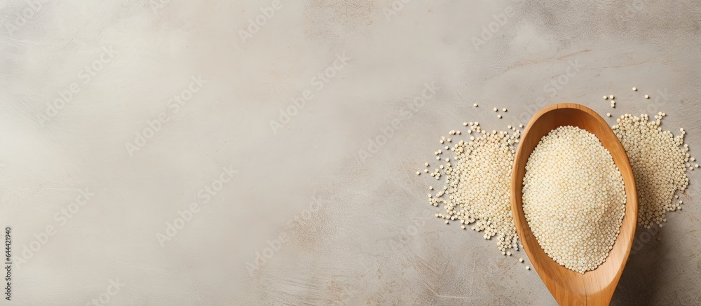 Organic white quinoa on a isolated pastel background Copy space viewed from above displayed in a wooden spoon
