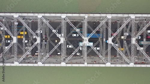 Aerial view of architectural landmark Howrah bridge or Rabindra Setu over the Hooghly River at night in Kolkata, West Bengal, India. photo