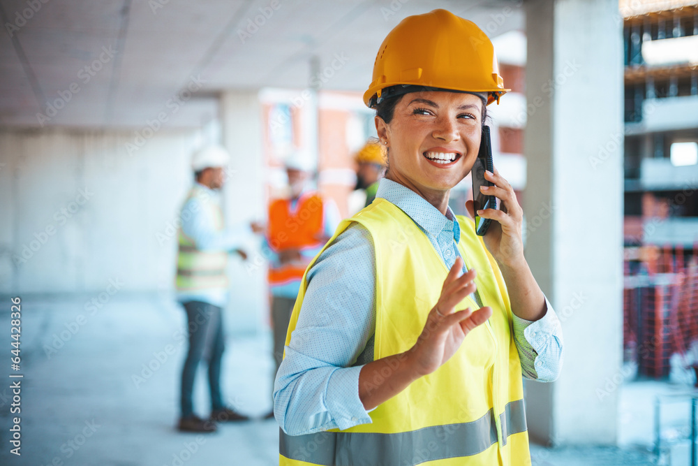 Shot of a young engineer using a smartphone in an industrial place of work. Architect is using mobile phone on construction site. She is focused on her work. Shot of a young engineer using a smartphone in an industrial place of work. Architect is using mobile phone on construction site. She is focused on her work.