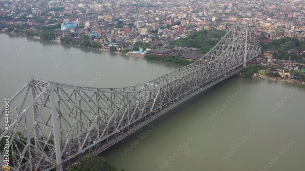 Aerial view of architectural landmark Howrah bridge or Rabindra Setu over the Hooghly River at night in Kolkata, West Bengal, India.