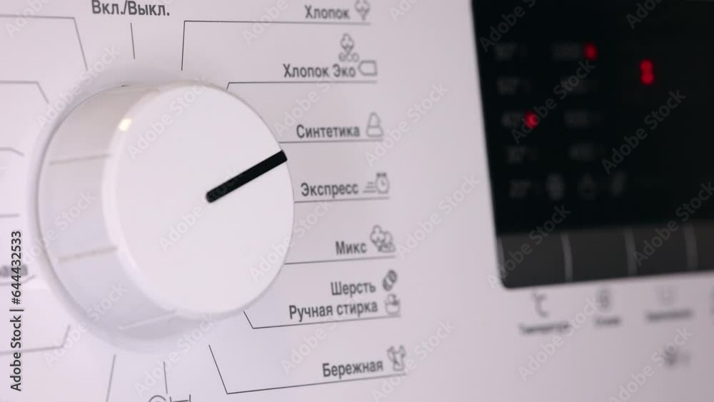 Hand Turns Dial On White Washing Machine. Selecting The Program On The Washing. Hand Turns Dial On White Washing Machine. Selecting The Program On The Washing.