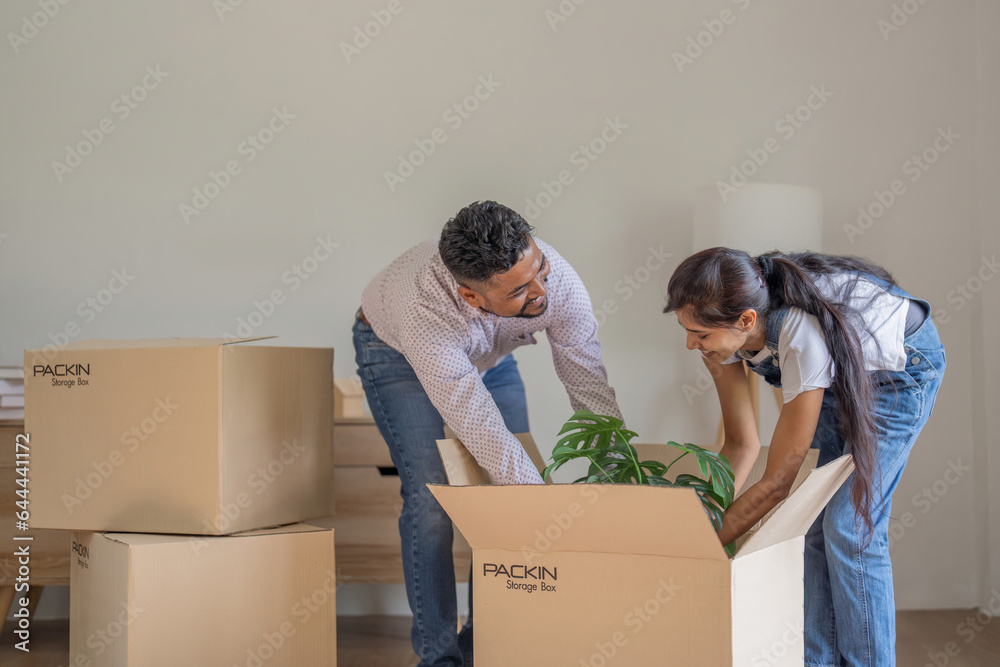 Couple Indian happy carrying box on moving day in of home new Couple Indian happy carrying box on moving day in of home new