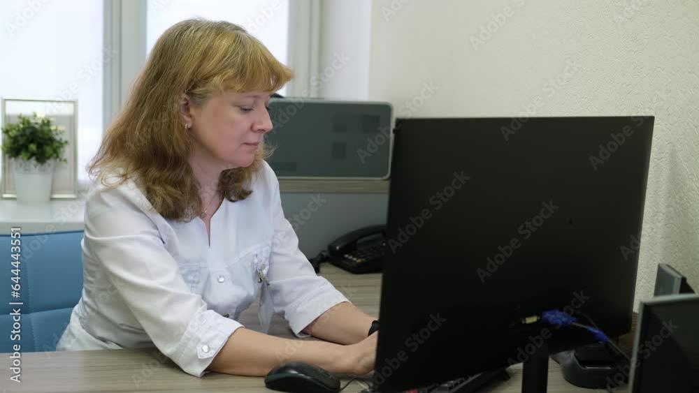 The doctor works in the office at the table using a computer. The doctor works in the office at the table using a computer.