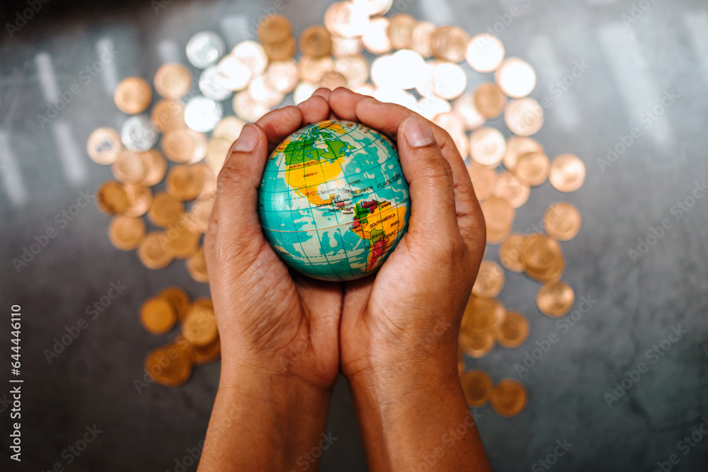 Globe in hand with gold coins background. money makes the world go round world financial situation concept Globe in hand with gold coins background. money makes the world go round world financial situation concept