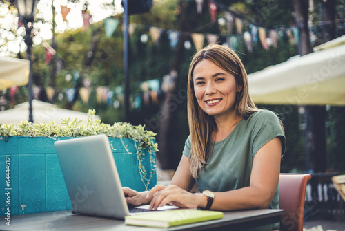 Shot of an attractive young woman using her laptop outdoors. Portrait of an attractive young businesswoman working on a laptop outdoors